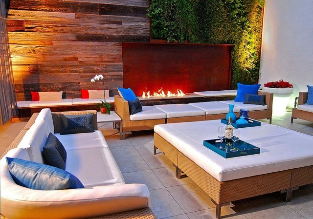 Ideias de design de terraço parede verde lareira assento almofada móveis de vime