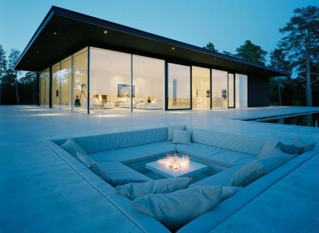Casa de vidro com almofadas de assento branco para fogueira ao ar livre