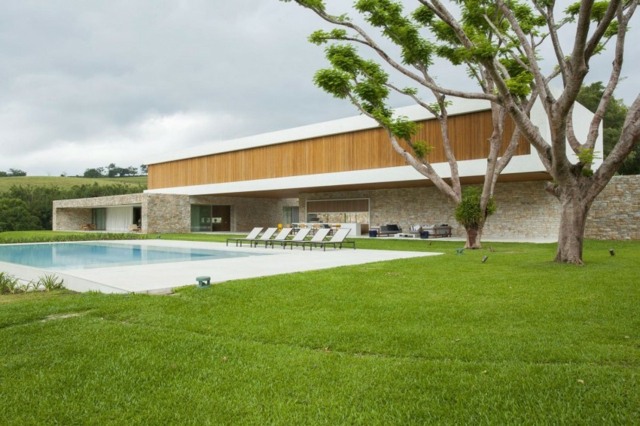 Casa com árvores altas e piscina com gramado