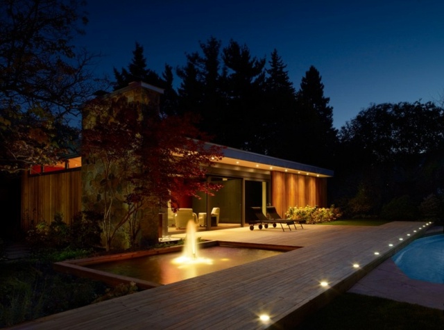 Iluminação da casa com fontes de árvores perenes