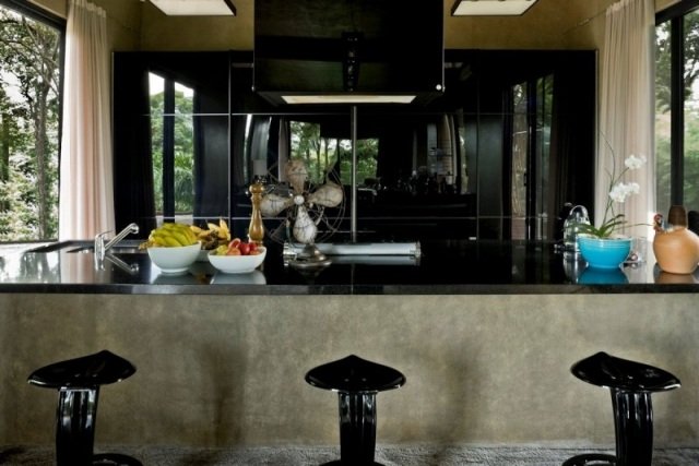 Cozinha de alto brilho, bancada frontal em laca preta, sólida construção em concreto, cadeiras de design