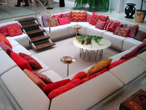 Sofá da sala de estar situado no fundo do chão com almofadas vermelhas e brancas
