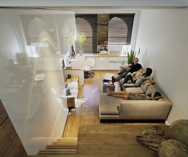 Mobília do pequeno apartamento com parede branca de alto brilho opticamente ampliada