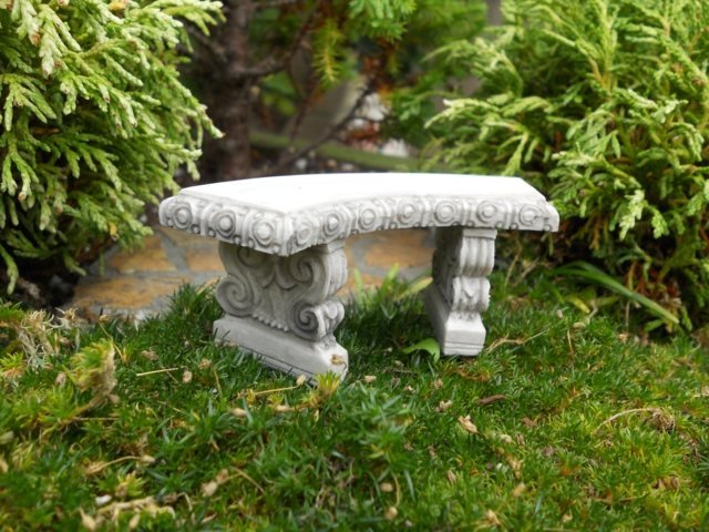 Pedra de jardim feita de assento romântico sob as árvores