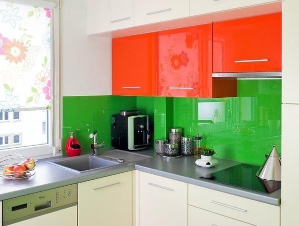 Parede traseira de vidro da cozinha, verde brilhante, frentes de armário laranja