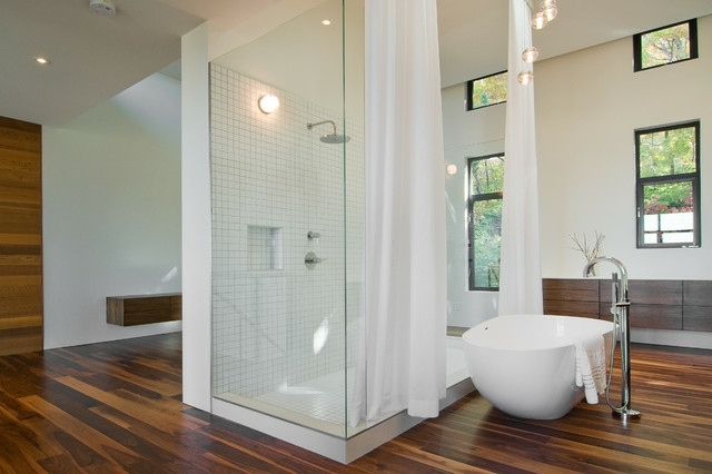 Cabine de duche com parede de vidro e banheira de chão