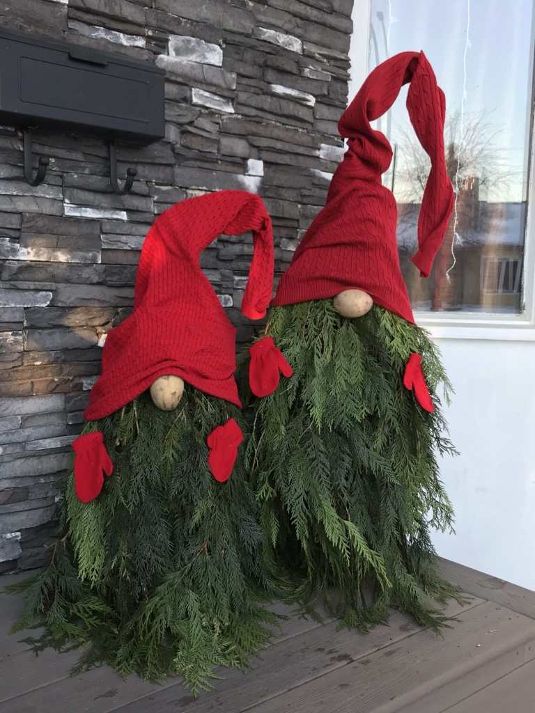 Decoração de Natal no terraço com galhos de cipreste enfeitados com chapéu pontudo de blusa velha