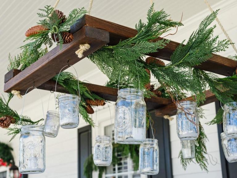 Disponha lanternas de terraço para decoração de Natal em potes de compota e ramos de abeto
