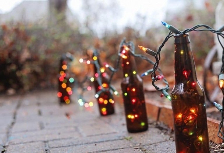 Decoração de Natal com luzes de fada no terraço e atmosfera festiva de garrafas de cerveja
