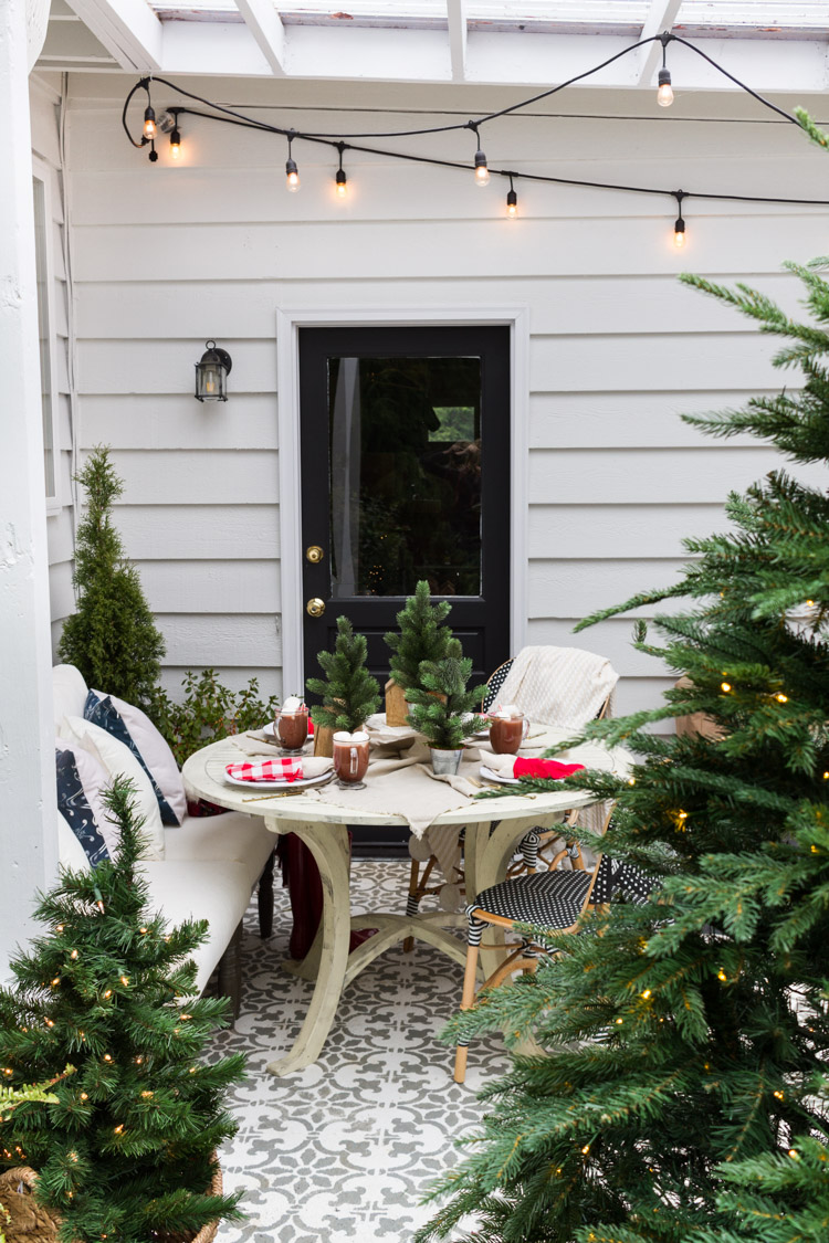 Decoração de Natal no terraço com mesa de jardim decorar festivamente a árvore de Natal com luzes de fadas