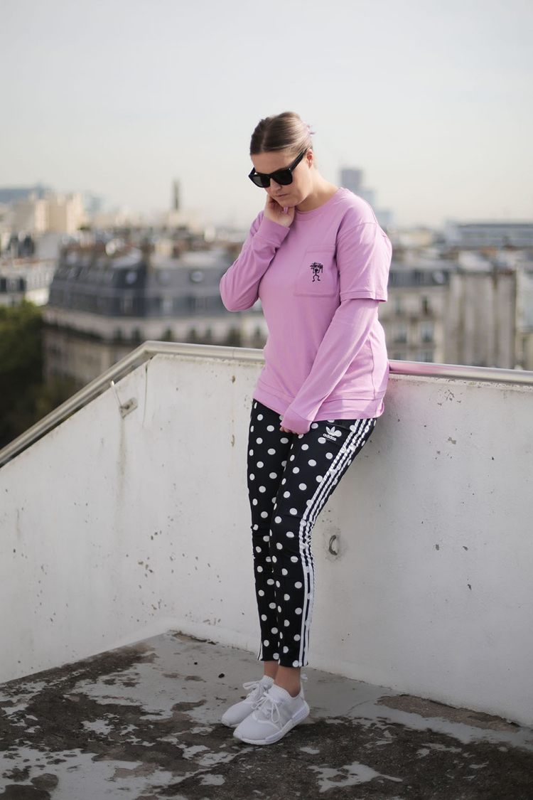 Calça esportiva branca Adidas NMD com padrão de pontos e blusa rosa