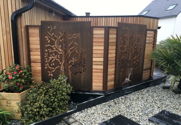 Painéis de Corten na frente de uma cerca de madeira