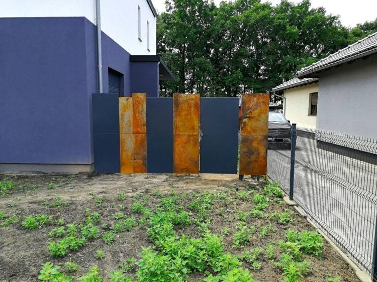 Tela de privacidade de aço corten para uma casa moderna com painéis azuis escuros