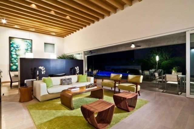 sala de estar com teto de madeira design acentos verdes cadeiras de carpete
