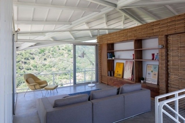 sala de relaxamento sistema de prateleiras de madeira portas de correr varanda piso de concreto polido
