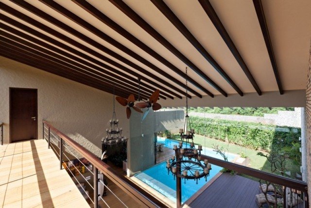 casa com telhado inclinado e piscina com pé direito duplo lustre vintage