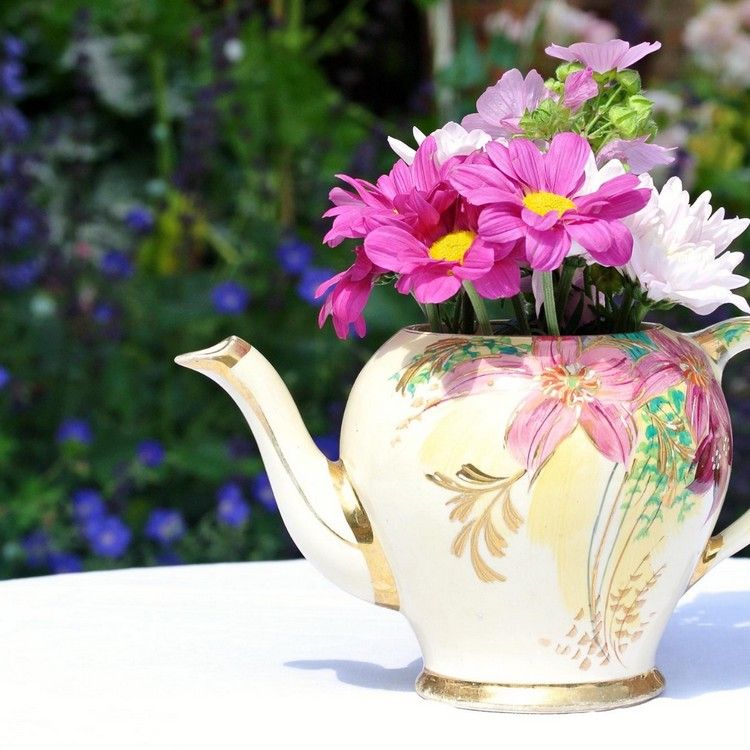 Corte flores em um bule vintage como um vaso