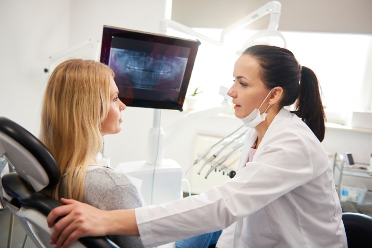 Dentista acalma paciente durante exame médico evita medo dentário