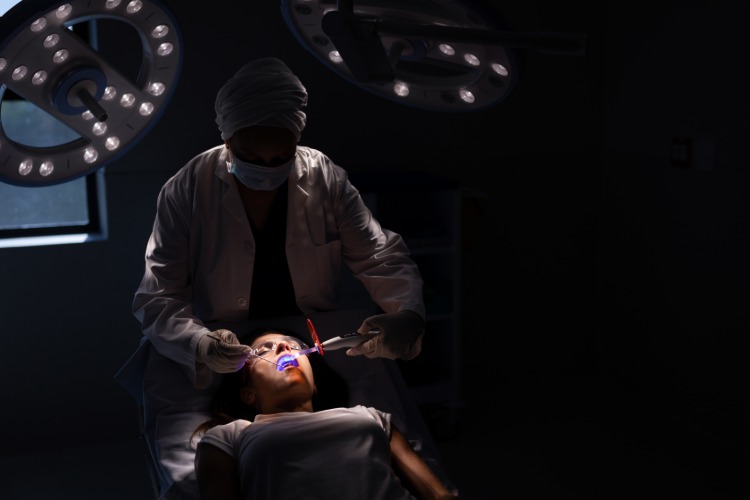 Tratamento odontológico realizado na sala escura do paciente - medo do dentista