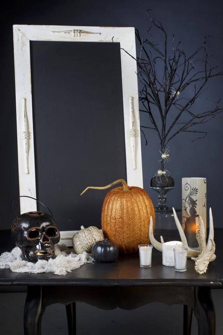 Decoração de mesa de Halloween com galhos pintados de abóbora e caveira