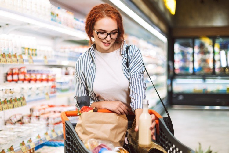 jovem no supermercado comprando comida saudável