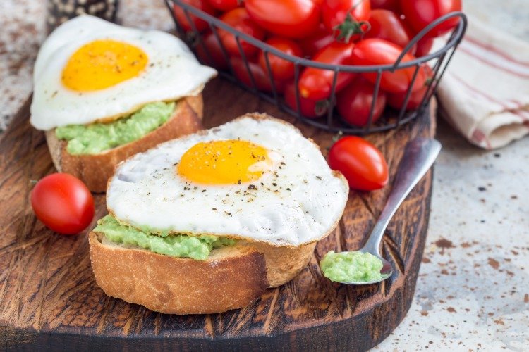 ovos fritos no pão com pasta de abacate e tomate cereja