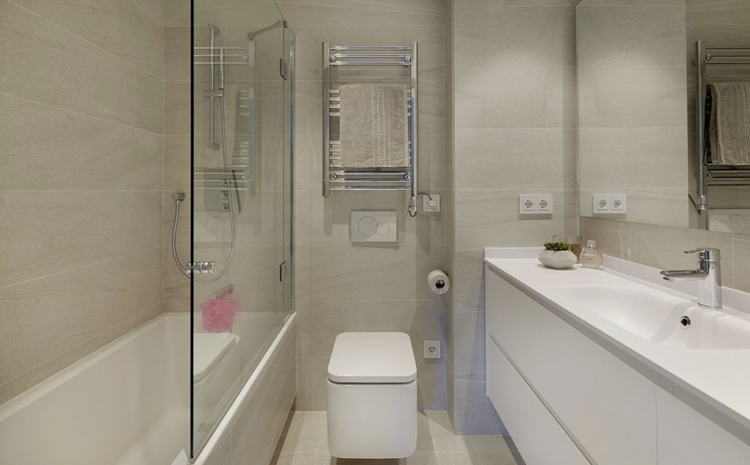 Tornar o banheiro bege branco com azulejos óticos de pedra e uma banheira com parede de vidro