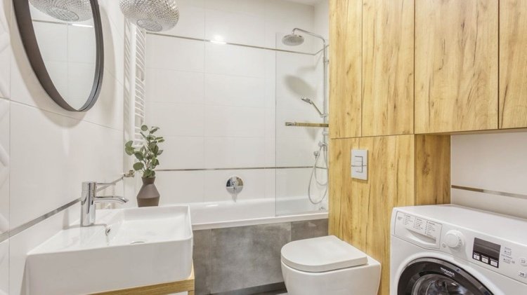 Banheiro moderno com uma bela combinação de cinza branco e máquina de lavar de madeira