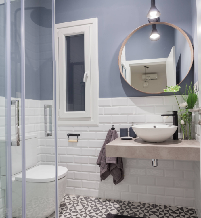 Casa de banho com azulejos metropolitanos brancos colocados na metade e na cor cinza-azulada da parede