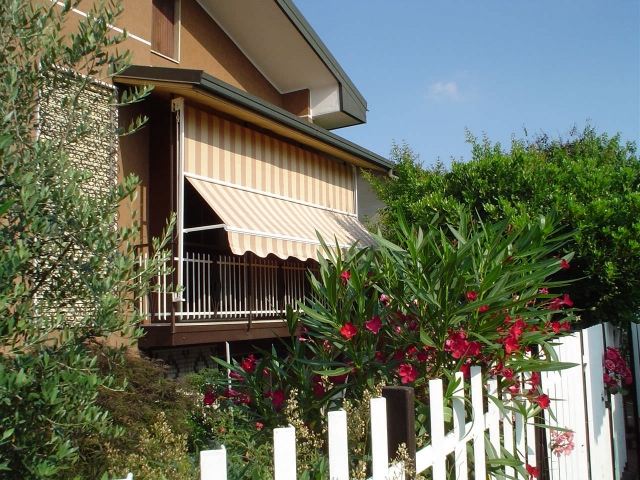 Prenda a vista do toldo da varanda com proteção solar listrada