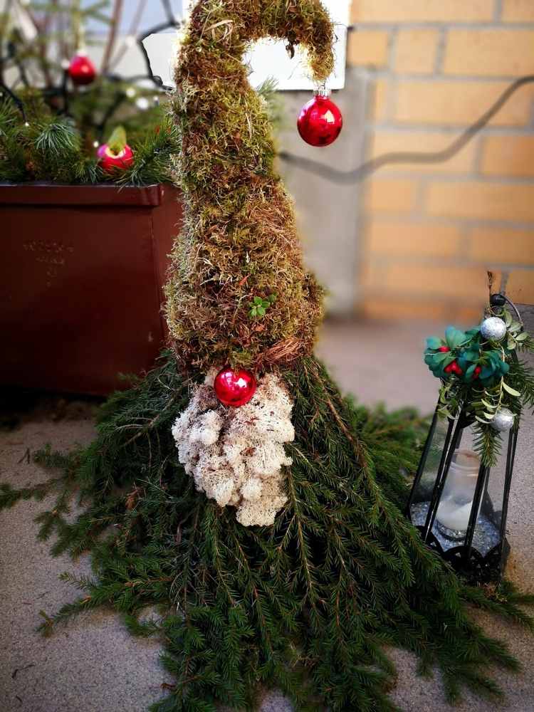 Gnomos feitos de musgo e ramos de abeto como decoração de varandas e terraços