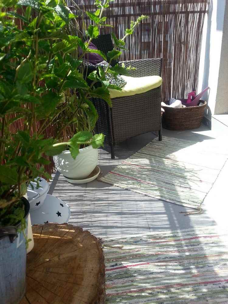Varanda com tela de privacidade de bambu com corrimão de poltrona de vime