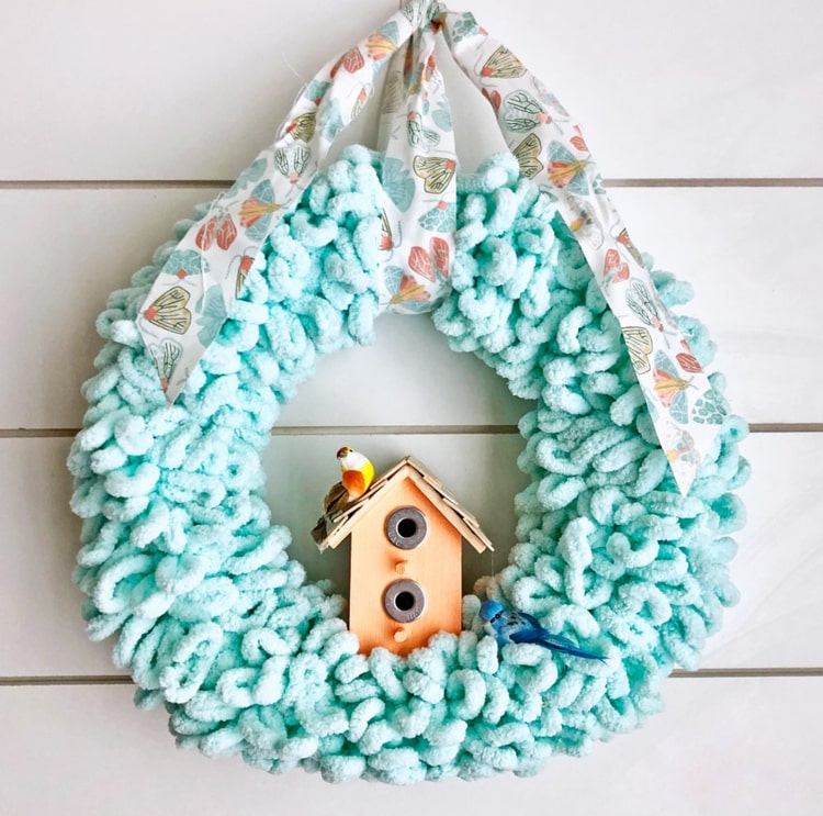 Lã azul claro fora do gancho e casinha de pássaros para um projeto de DIY de primavera