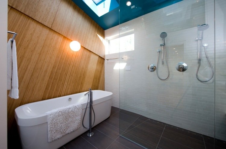 Fotos cabine de chuveiro de vidro, banheira independente, piso de ladrilhos escuros, parede de vidro