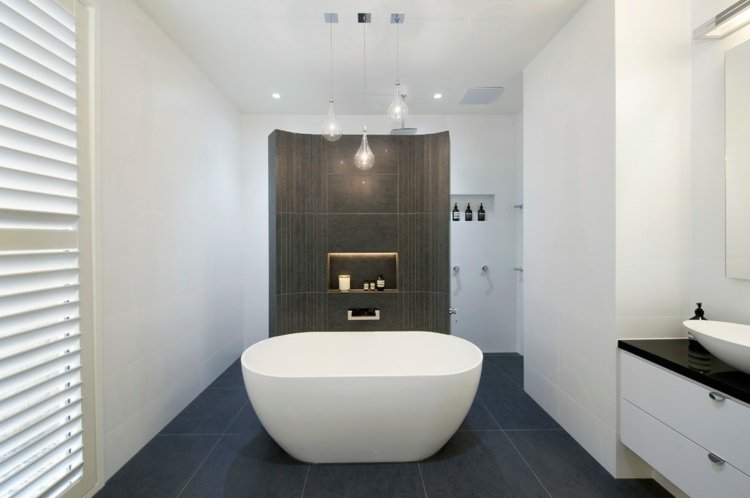Casas de banho com azulejos de cor escura e banheira independente moderna