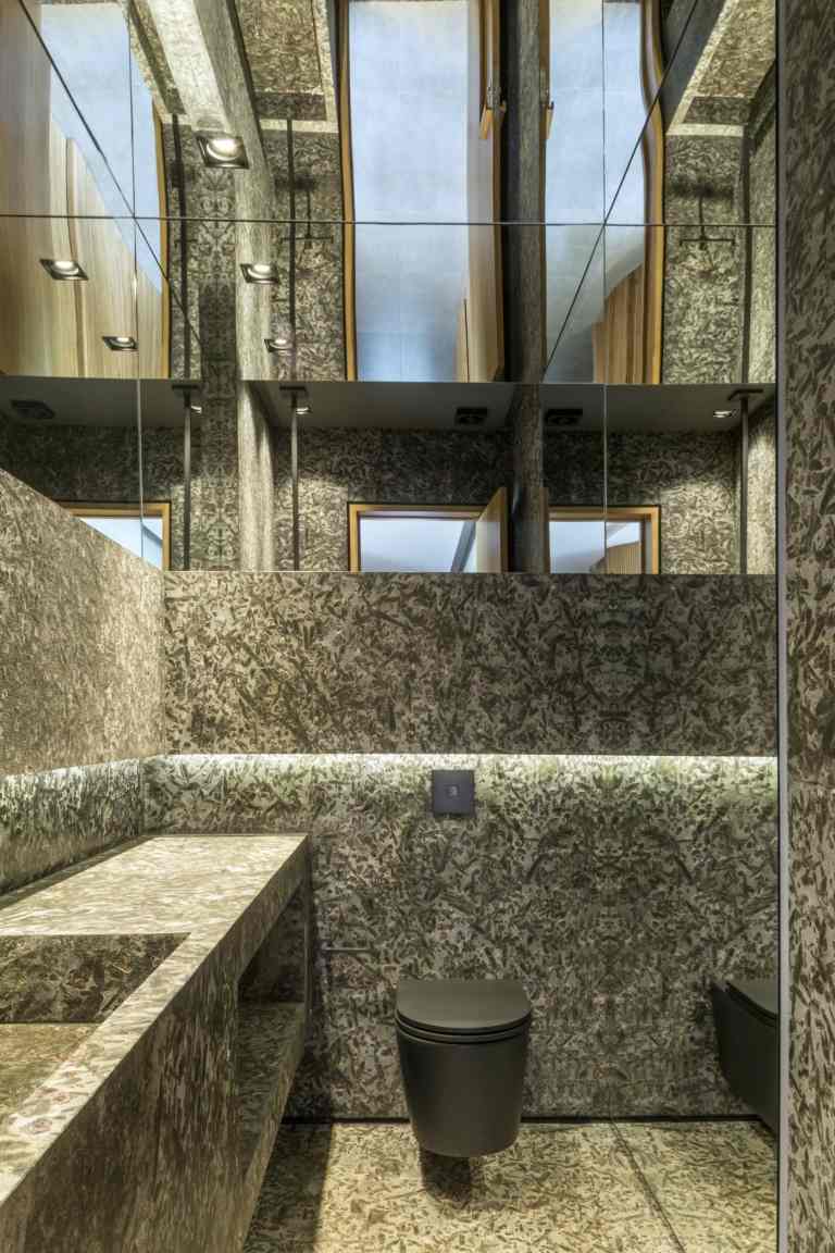 Banheiro atraente em pedra cinza com superfícies espelhadas