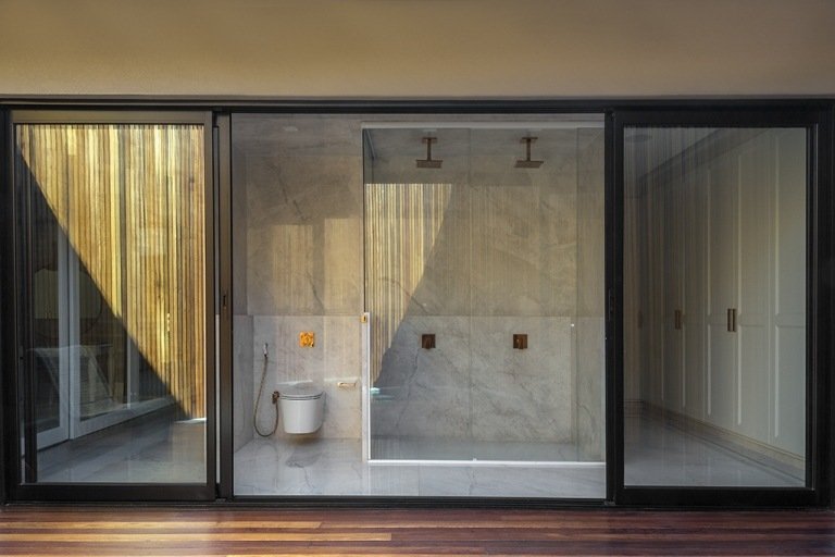 Casa de banho com WC e duche e janelas ao nível do chão com vista para o jardim