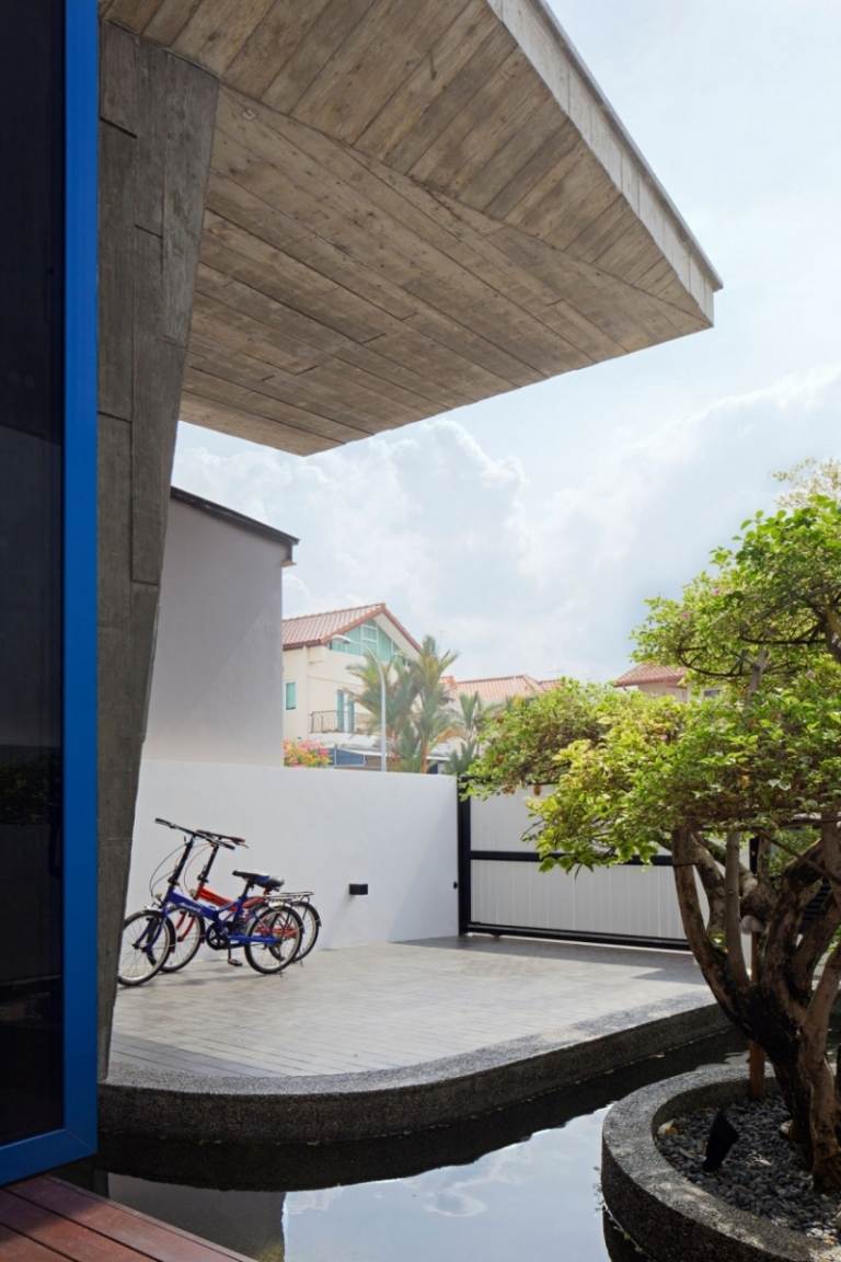 paredes de concreto-interior-jardim-casa-singapura-quintal-água-árvore-bicicleta-casa-porta