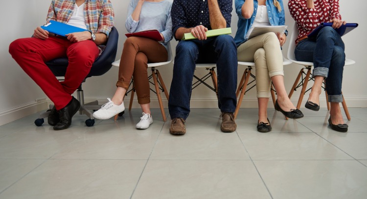 Vários candidatos para o emprego estão sentados à espera de uma entrevista