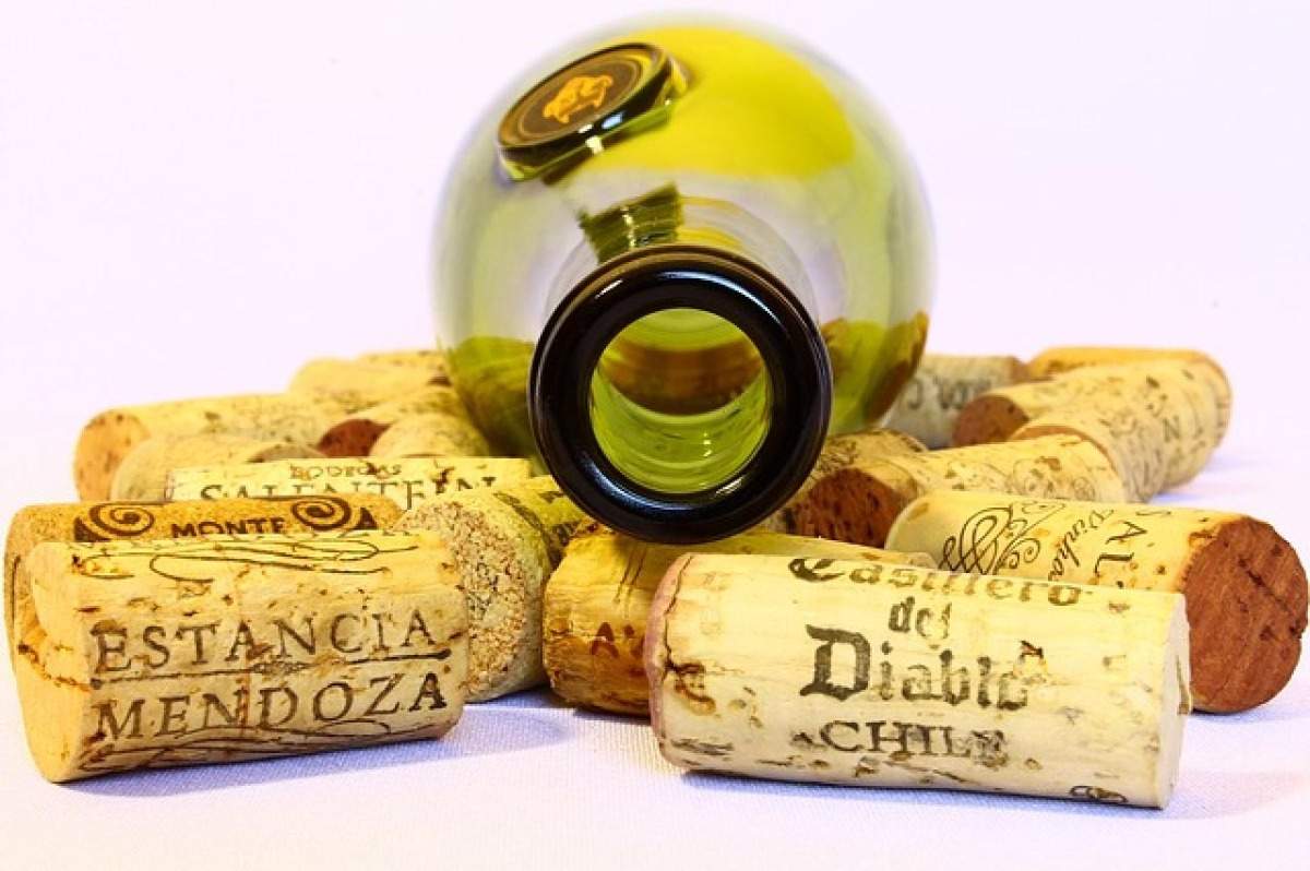 Garrafa de vinho vazia com rolhas de diferentes marcas para reduzir o consumo de álcool