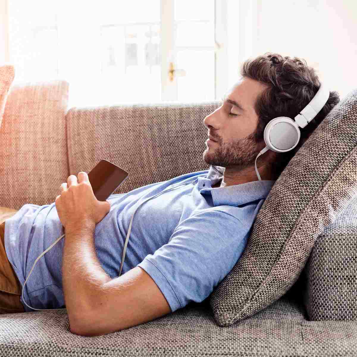 relaxe no sofá com fones de ouvido em casa e reduza o estresse