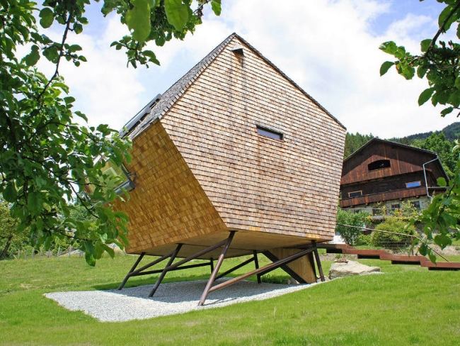 Casa de madeira projetada para férias em uma encosta de palafitas com sistema de proteção solar totalmente automático