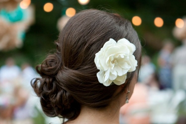 penteados de noiva dobrados de lado, acessório de cabelo com flores e cachos