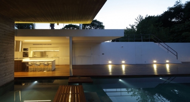 Iluminação da fachada de vidro do bunker de concreto da casa embutida no terraço da cobertura piscina design ao ar livre