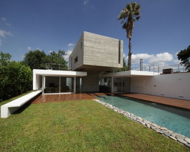 Casa moderna de concreto, telhado plano em balanço, piscina-estrutura, área com gramado