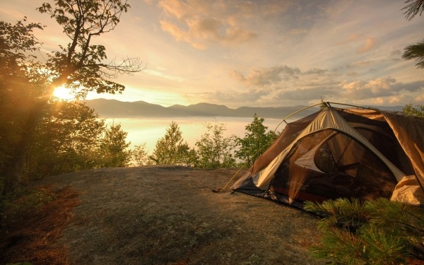 Acampar em barracas de camping modernas à beira do lago