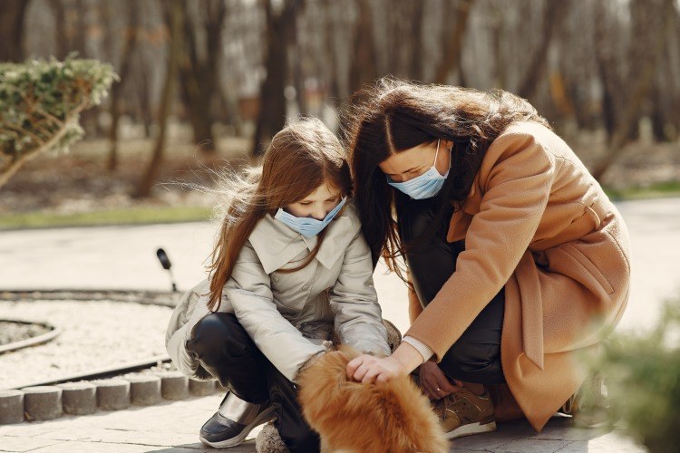 mãe e filha acariciando o animal sob o sol na corona coletam vitamina d