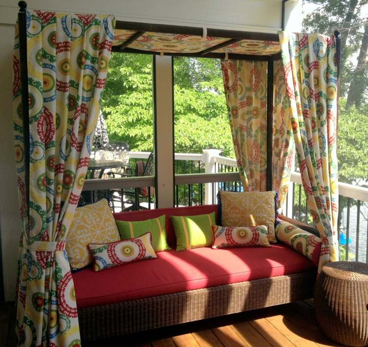Espreguiçadeira colorida na varanda externa com cortinas orgânicas