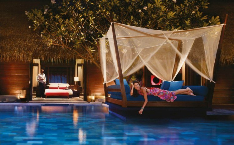 exótica cama externa com almofada azul dossel piscina