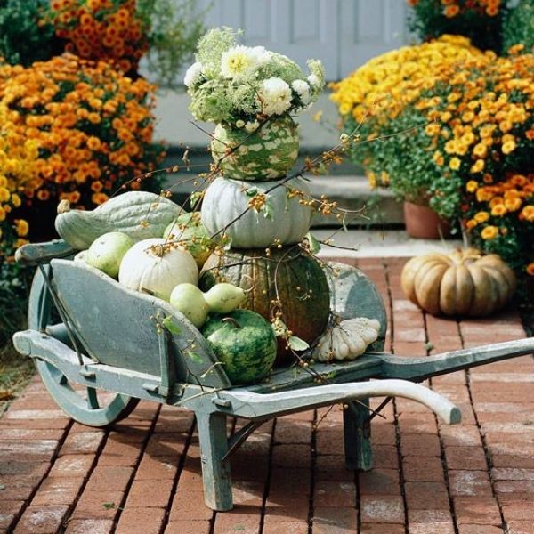 Carrinho de mão decorativo de abóbora ao ar livre pavimentando revestimentos de pedra - decoração de outono varanda